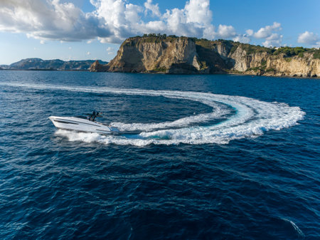 Aerial view of a motor boat in the sea with mountains in the backgroundの写真素材