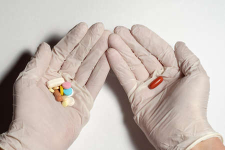 The concept of a new drug, hands in gloves with pills. The concept of the development of...
