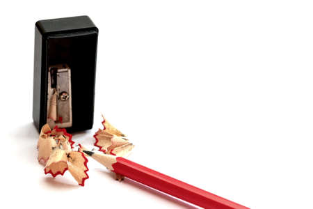 Pencil with sharpener and shavings on white background
