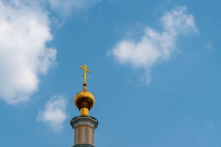 Golden dome and cross of Church on blue sky background with cirrus clouds with copy space.の写真素材