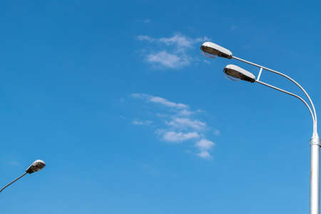 Street lights against the blue sky with clouds. Copy space.