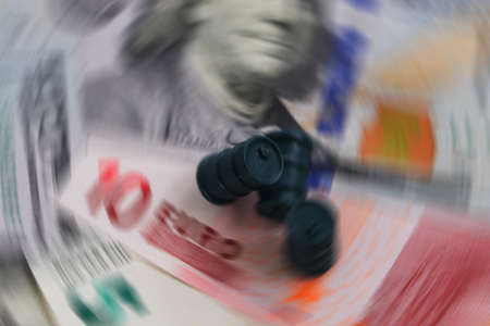 Radial blur filter photograph of oil kegs against the background of dollar and euro bills.の写真素材
