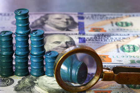Defocused image photographs view through magnifying glass on oil barrels and one hundred dollar billsの写真素材