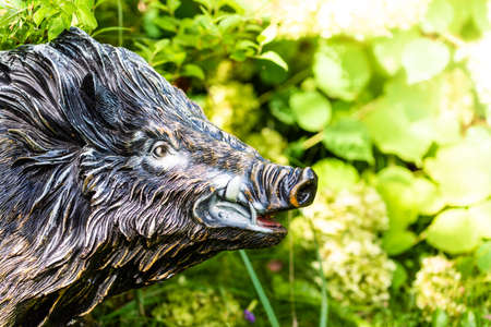 Fragment of a wild boar garden figure on a blurred nature backgroundの写真素材