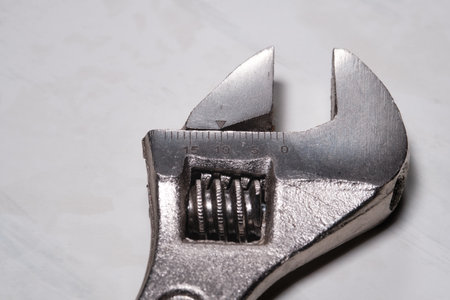 Fragment of an adjustable wrench on a light background. Close-up. Selective focus.の写真素材