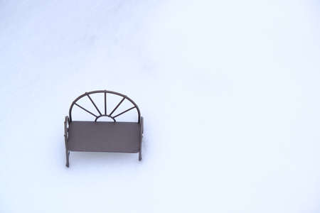 Miniature bench in the snow. Minimalism, milancholy and loneliness. Space for lettering and design. Selective focus.の写真素材