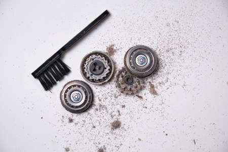 Details of a disassembled dirty shaver head and a cleaning brush on a light background. Soft selective focus. Copy spaceの写真素材