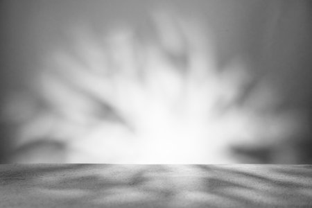 Monochrome background with podium and abstract blurred light pattern. Space for lettering, design, and presentation.の写真素材