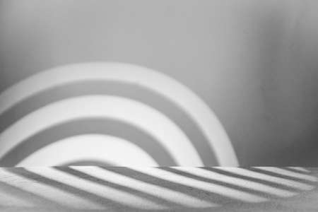 Monochrome background with podium and abstract blurred light pattern. Space for lettering, design, and presentation.の写真素材