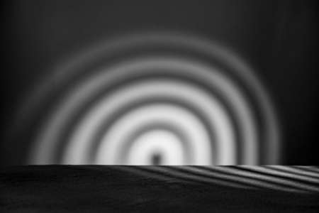 Monochrome background with podium and abstract blurred light pattern. Space for lettering, design,...