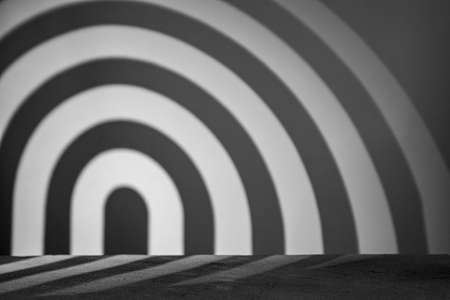 Monochrome background with podium and abstract blurred light pattern. Space for lettering, design, and presentation.の写真素材
