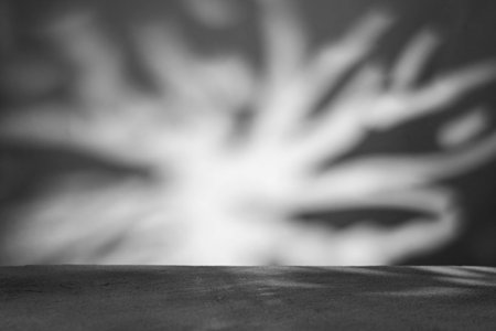 Monochrome background with podium and abstract blurred light pattern. Space for lettering, design, and presentation.の写真素材