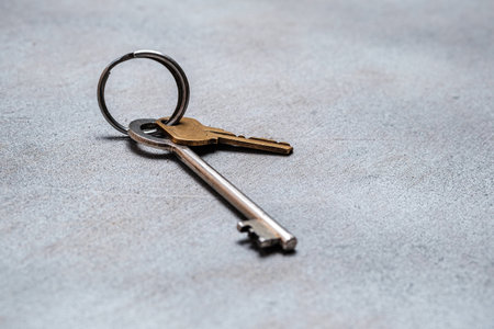 Two old keys on a ring on an abstract gray background. Selective focus. Space for lettering and designの写真素材