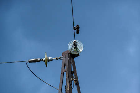 Fragment of an old high-voltage tower against the sky. Close-up. Selective focus.の写真素材