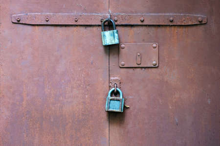 Old rusting metal gate with two padlocks. Space for lettering or design.の写真素材