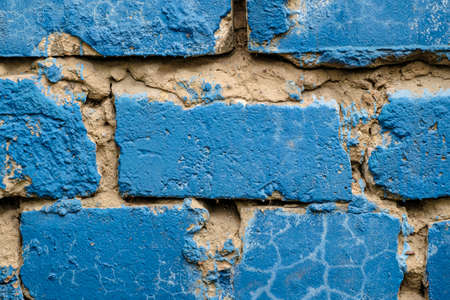 Old brick wall with uneven cement layer painted blue. Close-up. Copy spaceの写真素材