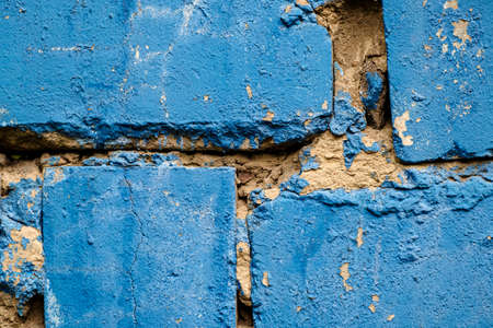 Old brick wall with uneven cement layer painted blue. Close-up. Copy spaceの写真素材