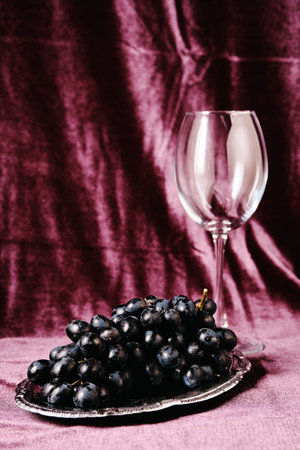 Still life of grapes and glass out of focus on a purple background. Beautiful minimal conceptの写真素材