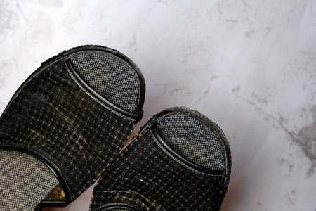 Fragment of old shabby house slippers on a light background. close-up. selective focus.