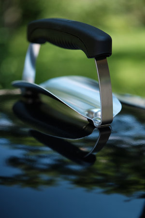Handle of the grill lid with a heat separator on a blurred natural background. close-up. selective focusの写真素材