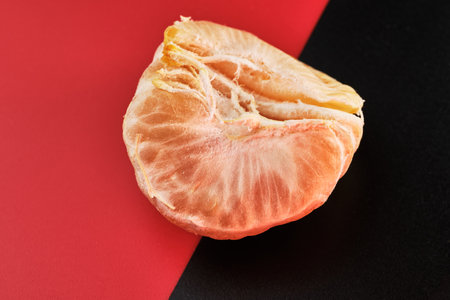 Close-up of mandarin slices on a red-black background. selective focus.の写真素材
