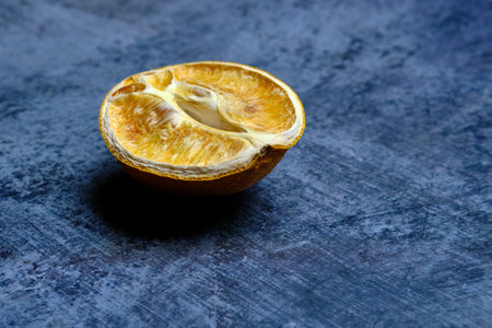 Half of a dried orange on an abstract blue background. close-up. selective focus.の写真素材