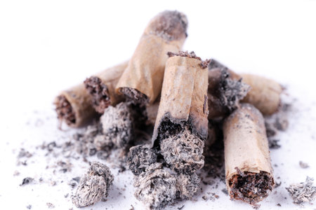 Cigarette butts, hand-rolled cigarettes and ashes. white background. close-up. selective focus.の写真素材