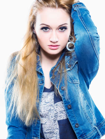 Horizontal color image   Studio shot of a young and attractive female model showing confidence wearing a grey tshirt and denim jacket   On white background の写真素材