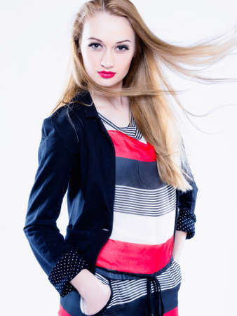 Horizontal color image   Studio shot of a young and attractive female model showing confidence wearing a stripe blouse and black jacket   On white background の写真素材