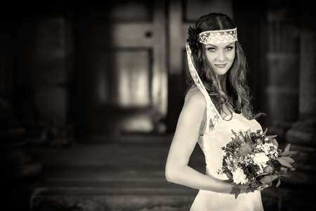 Beautiful Happy bride with wedding flowers bouquet in white dress with wedding hairstyle and makeup  Smiling woman in wedding dress waiting for groom  Pretty brunette girl bride  Jewelry and Beautyの写真素材