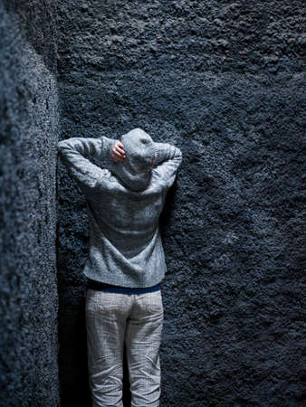 Scared, insane woman hiding in a corner of an ancient building の写真素材