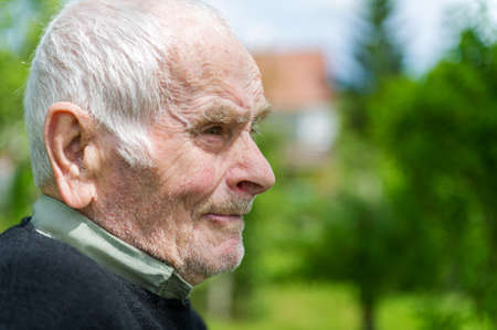 Handsome 80 plus year old senior man posing for a portrait in his garden  の写真素材