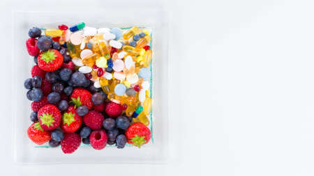 Healthy lifestyle, diet concept, Fruit and pills, vitamin supplements with copy space on white backgroundの写真素材