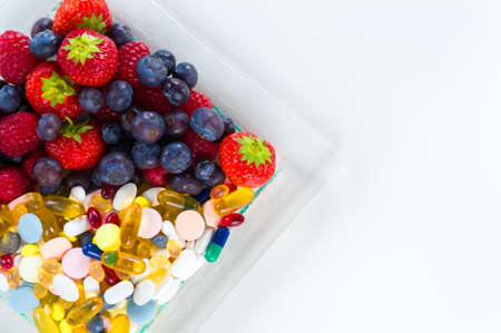 Healthy lifestyle, diet concept, Fruit and pills, vitamin supplements with copy space on white backgroundの写真素材