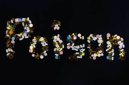Tablets, pills and capsules, that create word poison, on black backgroundの写真素材