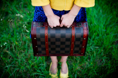 unrecognizable girl holding retro vintage suitcase, travel concept, change and move conceptの写真素材