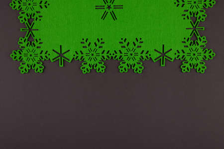 Unusual design christmas background with green snowflakes and copy space on dark grey backgroundの写真素材