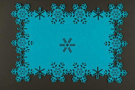 Unusual design christmas background with blue snowflakes and copy space on dark grey backgroundの写真素材
