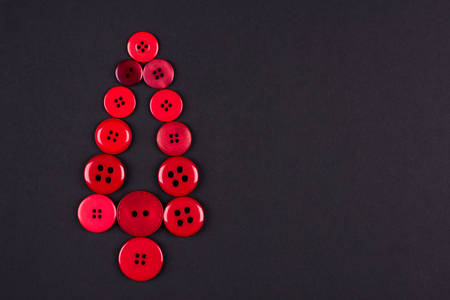 Unusual christmas tree design, red buttons tree christmas background, isolated on dark grey with copy spaceの写真素材