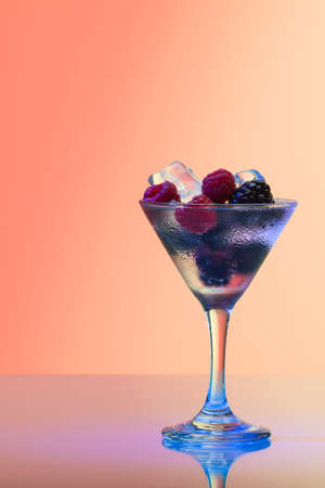 Refreshing raspberry and blackberry cocktail with ice, studio shot