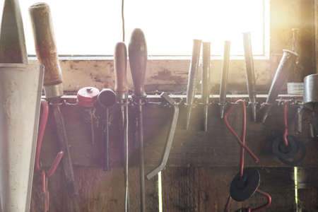 Set of various handyman tools, with sunflare coming through the windowの写真素材