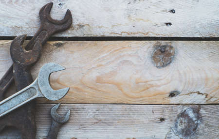 Various size spanners, wrenches on wooden background, colorised vintage feel