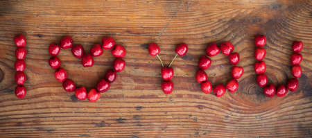 Ripe organic homegrown cherries on wooden background, I love you textの写真素材