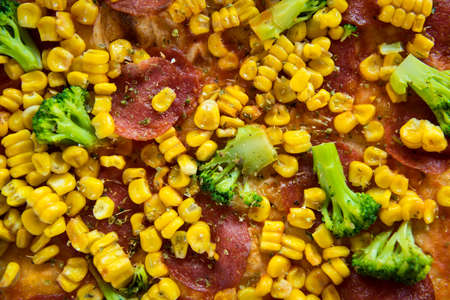 Pizza with salami, sweetcorn and broccoliの写真素材