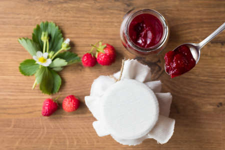 Homemade strawberry jam (marmelade) in jars on wooden background.の写真素材