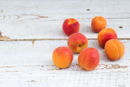 Fresh homegrown apricots on vintage white wooden tableの写真素材