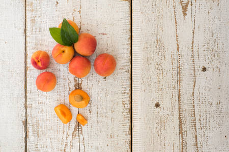 Fresh homegrown apricots on vintage white wooden table, view from aboveの写真素材