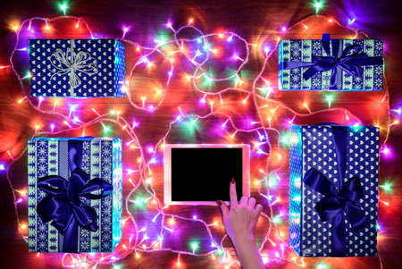 Desk view from above with female hands and digital tablet, xmas online shopping conceptの写真素材