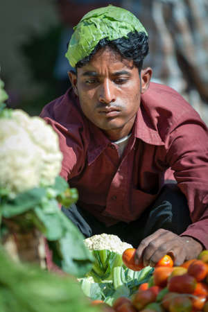 Goa, India - February 2008 - Young man selling fresh vegetables at the famous weekly Mapusa Marketのeditorial素材