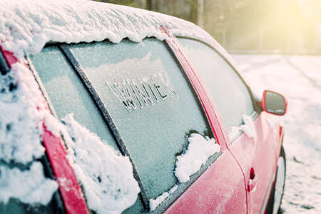 Frozen car window, car parked outside, winter transport issues